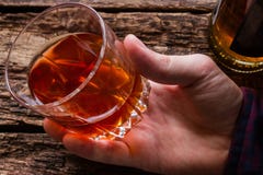 Οινοπνευματώδες άτομο που κρατά ένα ποτήρι του ουίσκυ στοκ εικόνα με δικαίωμα ελεύθερης χρήσης Οινοπνευματώδες άτομο που κρατά ένα ποτήρι του ουίσκυ στοκ εικόνα με δικαίωμα ελεύθερης χρήσης