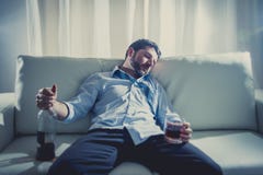 Οινοπνευματώδες επιχειρησιακό άτομο στον μπλε χαλαρό ύπνο δεσμών που πίνεται με το μπουκάλι ουίσκυ στον καναπέ στοκ εικόνες Οινοπνευματώδες επιχειρησιακό άτομο στον μπλε χαλαρό ύπνο δεσμών που πίνεται με το μπουκάλι ουίσκυ στον καναπέ στοκ εικόνες