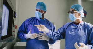 Ομάδα των χειρούργων που χρησιμοποιούν τη νέα τεχνολογία στη χειρουργική επέμβαση στοκ εικόνες Ομάδα των χειρούργων που χρησιμοποιούν τη νέα τεχνολογία στη χειρουργική επέμβαση στοκ εικόνες