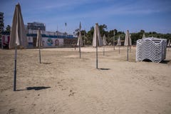 Ομπρέλες θαλάσσης στην παραλία με τα κρεβάτια ήλιων στοκ φωτογραφία με δικαίωμα ελεύθερης χρήσης Ομπρέλες θαλάσσης στην παραλία με τα κρεβάτια ήλιων στοκ φωτογραφία με δικαίωμα ελεύθερης χρήσης