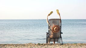 Οπισθοσκόπος γυναίκα στο μόνιππο παραλιών longue που κυματίζει τις σαγιονάρες της απόθεμα βίντεο Οπισθοσκόπος γυναίκα στο μόνιππο παραλιών longue που κυματίζει τις σαγιονάρες της απόθεμα βίντεο