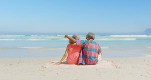 Οπισθοσκόπος της ενεργού ανώτερης χαλάρωσης ζευγών αφροαμερικάνων στο κάλυμμα στην ηλιοφάνεια στην παραλία 4k απόθεμα βίντεο Οπισθοσκόπος της ενεργού ανώτερης χαλάρωσης ζευγών αφροαμερικάνων στο κάλυμμα στην ηλιοφάνεια στην παραλία 4k απόθεμα βίντεο