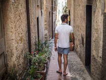 Οπισθοσκόπος του ατόμου που περπατά στην παλαιά ιταλική πόλη στοκ φωτογραφία με δικαίωμα ελεύθερης χρήσης Οπισθοσκόπος του ατόμου που περπατά στην παλαιά ιταλική πόλη στοκ φωτογραφία με δικαίωμα ελεύθερης χρήσης