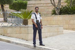 Οπλισμένο άτομο προσωπικό ασφαλείας το σημείο ελέγχου οχημάτων στην παρακαμπτήριο οδό στην είσοδο στα ισραηλινά κτήρια της Κνεσέτ στοκ εικόνα με δικαίωμα ελεύθερης χρήσης Οπλισμένο άτομο προσωπικό ασφαλείας το σημείο ελέγχου οχημάτων στην παρακαμπτήριο οδό στην είσοδο στα ισραηλινά κτήρια της Κνεσέτ στοκ εικόνα με δικαίωμα ελεύθερης χρήσης