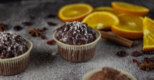 Ορεκτική κινηματογράφηση σε πρώτο πλάνο muffins σε ένα σκοτεινό υπόβαθρο με τις φέτες των πορτοκαλιών στοκ εικόνα Ορεκτική κινηματογράφηση σε πρώτο πλάνο muffins σε ένα σκοτεινό υπόβαθρο με τις φέτες των πορτοκαλιών στοκ εικόνα