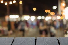Πλαστή επάνω μαύρη ξύλινη επιτραπέζια πηγή και θολωμένη οδός περπατήματος backg στοκ εικόνα Πλαστή επάνω μαύρη ξύλινη επιτραπέζια πηγή και θολωμένη οδός περπατήματος backg στοκ εικόνα