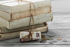 Παλαιά άσπρα βιβλία με τα χρήματα και νομίσματα στο ξύλινο υπόβαθρο Στοκ Φωτογραφίες Παλαιά άσπρα βιβλία με τα χρήματα και νομίσματα στο ξύλινο υπόβαθρο Στοκ Φωτογραφίες