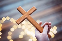 Παιδί μικρών παιδιών που προσεύχεται και που κρατά ξύλινο crucifix στοκ φωτογραφίες Παιδί μικρών παιδιών που προσεύχεται και που κρατά ξύλινο crucifix στοκ φωτογραφίες
