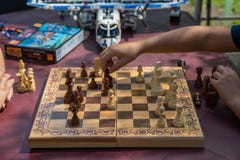 Παιδιά που παίζουν το σκάκι στον κήπο με τα θολωμένα παιχνίδια στο υπόβαθρο στοκ εικόνα Παιδιά που παίζουν το σκάκι στον κήπο με τα θολωμένα παιχνίδια στο υπόβαθρο στοκ εικόνα