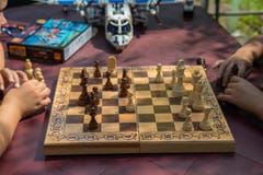 Παιδιά που παίζουν το σκάκι στον κήπο με τα θολωμένα παιχνίδια στο υπόβαθρο στοκ εικόνες Παιδιά που παίζουν το σκάκι στον κήπο με τα θολωμένα παιχνίδια στο υπόβαθρο στοκ εικόνες