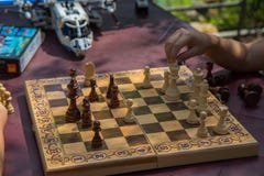 Παιδιά που παίζουν το σκάκι στον κήπο με τα θολωμένα παιχνίδια στο υπόβαθρο στοκ φωτογραφία με δικαίωμα ελεύθερης χρήσης Παιδιά που παίζουν το σκάκι στον κήπο με τα θολωμένα παιχνίδια στο υπόβαθρο στοκ φωτογραφία με δικαίωμα ελεύθερης χρήσης