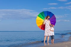 Παιχνίδι μητέρων και γιων με την ομπρέλα στην παραλία στην ημέρα tim στοκ φωτογραφίες Παιχνίδι μητέρων και γιων με την ομπρέλα στην παραλία στην ημέρα tim στοκ φωτογραφίες