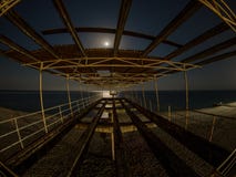 Παλαιά συγκεκριμένη αποβάθρα στην παραλία τη νύχτα στο σεληνόφωτο στοκ φωτογραφία Παλαιά συγκεκριμένη αποβάθρα στην παραλία τη νύχτα στο σεληνόφωτο στοκ φωτογραφία