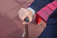 Παλαιό ραβδί περπατήματος εκμετάλλευσης χεριών ατόμων υπαίθριο στοκ φωτογραφία με δικαίωμα ελεύθερης χρήσης Παλαιό ραβδί περπατήματος εκμετάλλευσης χεριών ατόμων υπαίθριο στοκ φωτογραφία με δικαίωμα ελεύθερης χρήσης