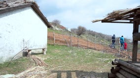 Πανοραμική όψη του χωριού Παλαιά μαύρη ξύλινη βάρκα με ένα one-storey σπίτι, καλά και έναν λόφο Παλαιός ξύλινος φιλμ μικρού μήκους Πανοραμική όψη του χωριού Παλαιά μαύρη ξύλινη βάρκα με ένα one-storey σπίτι, καλά και έναν λόφο Παλαιός ξύλινος φιλμ μικρού μήκους