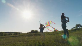 Πατέρας με τα παιδιά που προωθούν έναν ικτίνο αέρα απόθεμα βίντεο Πατέρας με τα παιδιά που προωθούν έναν ικτίνο αέρα απόθεμα βίντεο