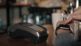 Πελάτης που πληρώνει με την τεχνολογία NFC από το έξυπνο ρολόι ανέπαφο στο τερματικό στο σύγχρονο καφέ απόθεμα βίντεο Πελάτης που πληρώνει με την τεχνολογία NFC από το έξυπνο ρολόι ανέπαφο στο τερματικό στο σύγχρονο καφέ απόθεμα βίντεο