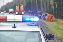 Περιπολικό της Αστυνομίας με έναν αναλαμπτήρα στη συντριβή φορτηγών Στοκ εικόνα με δικαίωμα ελεύθερης χρήσης Περιπολικό της Αστυνομίας με έναν αναλαμπτήρα στη συντριβή φορτηγών Στοκ εικόνα με δικαίωμα ελεύθερης χρήσης