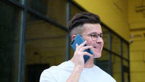 Περιστασιακός νεαρός άνδρας που χρησιμοποιεί το smartphone Κλείστε επάνω το πορτρέτο του ατόμου που μιλά στο smartphone που χαμογ απόθεμα βίντεο Περιστασιακός νεαρός άνδρας που χρησιμοποιεί το smartphone Κλείστε επάνω το πορτρέτο του ατόμου που μιλά στο smartphone που χαμογ απόθεμα βίντεο