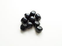 Πεφμένες μαύρες Obsidian πέτρες κοντά επάνω στον πίνακα για το κρύσταλλο ther στοκ εικόνες Πεφμένες μαύρες Obsidian πέτρες κοντά επάνω στον πίνακα για το κρύσταλλο ther στοκ εικόνες