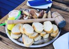 Πιάτο με τα βρασμένα πόδια και τα νύχια του καφετιού καβουριού με το ψωμί και εμβύθιση στον ξύλινο πίνακα στοκ εικόνες Πιάτο με τα βρασμένα πόδια και τα νύχια του καφετιού καβουριού με το ψωμί και εμβύθιση στον ξύλινο πίνακα στοκ εικόνες