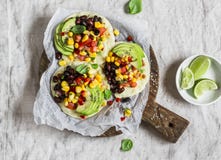 Πικάντικα tortillas φασολιών με το salsa και το αβοκάντο καλαμποκιού σε έναν αγροτικό τέμνοντα πίνακα σε ένα σκοτεινό υπόβαθρο στοκ εικόνα Πικάντικα tortillas φασολιών με το salsa και το αβοκάντο καλαμποκιού σε έναν αγροτικό τέμνοντα πίνακα σε ένα σκοτεινό υπόβαθρο στοκ εικόνα