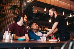 Πολυφυλετικά άτομα που συναντούν το φίλο τους στο φραγμό σαλονιών Πραγματικές συγκινήσεις των καλύτερων φίλων ευτυχών να δουν ο έ στοκ φωτογραφία με δικαίωμα ελεύθερης χρήσης Πολυφυλετικά άτομα που συναντούν το φίλο τους στο φραγμό σαλονιών Πραγματικές συγκινήσεις των καλύτερων φίλων ευτυχών να δουν ο έ στοκ φωτογραφία με δικαίωμα ελεύθερης χρήσης
