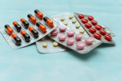 Πολύχρωμες χάπια και κάψες στην κινηματογράφηση σε πρώτο πλάνο φουσκαλών, στο μπλε υπόβαθρο Η έννοια της θεραπείας των ανθρώπινων στοκ φωτογραφία με δικαίωμα ελεύθερης χρήσης Πολύχρωμες χάπια και κάψες στην κινηματογράφηση σε πρώτο πλάνο φουσκαλών, στο μπλε υπόβαθρο Η έννοια της θεραπείας των ανθρώπινων στοκ φωτογραφία με δικαίωμα ελεύθερης χρήσης