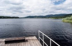 Πορθμείο στο υδραγωγείο Lipno με τα βουνά Sumava στο υπόβαθρο στοκ εικόνα με δικαίωμα ελεύθερης χρήσης Πορθμείο στο υδραγωγείο Lipno με τα βουνά Sumava στο υπόβαθρο στοκ εικόνα με δικαίωμα ελεύθερης χρήσης