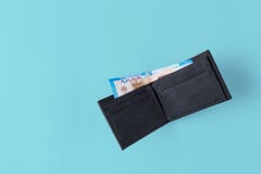 Πορτοφόλι πορτοφολιών δέρματος με τα χρήματα στο μπλε υπόβαθρο στοκ φωτογραφίες Πορτοφόλι πορτοφολιών δέρματος με τα χρήματα στο μπλε υπόβαθρο στοκ φωτογραφίες