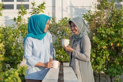 Πορτρέτο δύο γυναικών hijab που πίνουν το τσάι μπροστά από το σπίτι και την ομιλία στοκ εικόνες Πορτρέτο δύο γυναικών hijab που πίνουν το τσάι μπροστά από το σπίτι και την ομιλία στοκ εικόνες