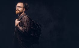 Πορτρέτο ενός redhead σπουδαστή hipster στα γυαλιά που ντύνονται σε ένα καφετί πουκάμισο, κρατά ένα σακίδιο πλάτης, που θέτει σε στοκ εικόνες Πορτρέτο ενός redhead σπουδαστή hipster στα γυαλιά που ντύνονται σε ένα καφετί πουκάμισο, κρατά ένα σακίδιο πλάτης, που θέτει σε στοκ εικόνες