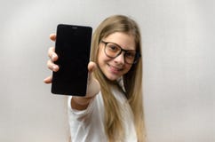Πορτρέτο ενός ξανθού κοριτσιού με ένα smartphone στο χέρι της Έξυπνη τεχνολογία Κινητή σύνδεση Smartphone παιδιών apps στοκ εικόνες με δικαίωμα ελεύθερης χρήσης Πορτρέτο ενός ξανθού κοριτσιού με ένα smartphone στο χέρι της Έξυπνη τεχνολογία Κινητή σύνδεση Smartphone παιδιών apps στοκ εικόνες με δικαίωμα ελεύθερης χρήσης