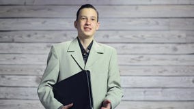 Πορτρέτο ενός όμορφου ευτυχούς χαμογελώντας ατόμου με έναν χαρτοφύλακα στο χαμόγελο χεριών του απόθεμα βίντεο Πορτρέτο ενός όμορφου ευτυχούς χαμογελώντας ατόμου με έναν χαρτοφύλακα στο χαμόγελο χεριών του απόθεμα βίντεο