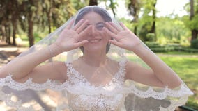 Πορτρέτο μιας ευτυχούς νύφης σε ένα πέπλο με ένα καλυμμένο κεφάλι σε ένα θερινό πάρκο απόθεμα βίντεο Πορτρέτο μιας ευτυχούς νύφης σε ένα πέπλο με ένα καλυμμένο κεφάλι σε ένα θερινό πάρκο απόθεμα βίντεο