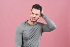 Πορτρέτο στούντιο σε ένα απομονωμένο υπόβαθρο ενός νέου αθλητικού ατόμου που χαμογελά και που γρατσουνίζει το κεφάλι του που συλλ Στοκ Εικόνα Πορτρέτο στούντιο σε ένα απομονωμένο υπόβαθρο ενός νέου αθλητικού ατόμου που χαμογελά και που γρατσουνίζει το κεφάλι του που συλλ Στοκ Εικόνα