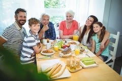 Πορτρέτο της ευτυχούς multi-generation οικογενειακής συνεδρίασης στον πίνακα προγευμάτων στοκ φωτογραφία με δικαίωμα ελεύθερης χρήσης Πορτρέτο της ευτυχούς multi-generation οικογενειακής συνεδρίασης στον πίνακα προγευμάτων στοκ φωτογραφία με δικαίωμα ελεύθερης χρήσης