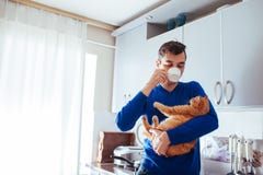 Πορτρέτο της όμορφων γάτας εκμετάλλευσης νεαρών άνδρων και του τσαγιού κατανάλωσης στην κουζίνα στοκ φωτογραφία με δικαίωμα ελεύθερης χρήσης Πορτρέτο της όμορφων γάτας εκμετάλλευσης νεαρών άνδρων και του τσαγιού κατανάλωσης στην κουζίνα στοκ φωτογραφία με δικαίωμα ελεύθερης χρήσης