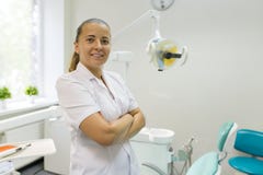 Πορτρέτο του θηλυκού οδοντιάτρου με τα διασχισμένα όπλα, γιατρός που χαμογελά στο οδοντικό υπόβαθρο καρεκλών Ιατρική, οδοντιατρικ στοκ φωτογραφία με δικαίωμα ελεύθερης χρήσης Πορτρέτο του θηλυκού οδοντιάτρου με τα διασχισμένα όπλα, γιατρός που χαμογελά στο οδοντικό υπόβαθρο καρεκλών Ιατρική, οδοντιατρικ στοκ φωτογραφία με δικαίωμα ελεύθερης χρήσης