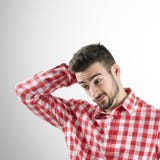 Πορτρέτο του ταραγμένου νέου γενειοφόρου ατόμου που κοιτάζει κάτω Στοκ Φωτογραφία Πορτρέτο του ταραγμένου νέου γενειοφόρου ατόμου που κοιτάζει κάτω Στοκ Φωτογραφία