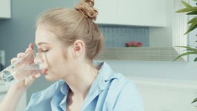 Πορτρέτο του υγιούς νέου ξανθού πόσιμου νερού γυναικών στο σπίτι απόθεμα βίντεο Πορτρέτο του υγιούς νέου ξανθού πόσιμου νερού γυναικών στο σπίτι απόθεμα βίντεο