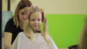 Πορτρέτο του χαριτωμένου μικρού κοριτσιού hairdressing στο σαλόνι απόθεμα βίντεο Πορτρέτο του χαριτωμένου μικρού κοριτσιού hairdressing στο σαλόνι απόθεμα βίντεο