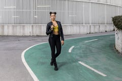 Πορτρέτο τρόπου ζωής μιας γυναίκας που φορά τις μαύρα περικνημίδες και το σακάκι δέρματος στοκ φωτογραφία Πορτρέτο τρόπου ζωής μιας γυναίκας που φορά τις μαύρα περικνημίδες και το σακάκι δέρματος στοκ φωτογραφία