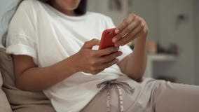 Πυροβοληθείς το των χεριών γυναικών ` s που κρατούν ένα smartphone καθμένος σε ένα οικογενειακό περιβάλλον φιλμ μικρού μήκους Πυροβοληθείς το των χεριών γυναικών ` s που κρατούν ένα smartphone καθμένος σε ένα οικογενειακό περιβάλλον φιλμ μικρού μήκους