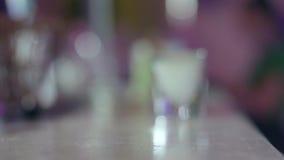Πυροβόλησε το γυαλί με ένα οινοπνευματώδες ποτό για τους πελάτες στο αντίθετο, θολωμένο υπόβαθρο φραγμών φιλμ μικρού μήκους Πυροβόλησε το γυαλί με ένα οινοπνευματώδες ποτό για τους πελάτες στο αντίθετο, θολωμένο υπόβαθρο φραγμών φιλμ μικρού μήκους