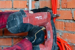 Πυροβόλο όπλο καρφιών Hilti που οδηγεί ένα καρφί σε έναν τοίχο στοκ εικόνα Πυροβόλο όπλο καρφιών Hilti που οδηγεί ένα καρφί σε έναν τοίχο στοκ εικόνα