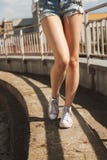 Πόδια γυναικών στα άσπρα gumshoes στοκ εικόνες με δικαίωμα ελεύθερης χρήσης Πόδια γυναικών στα άσπρα gumshoes στοκ εικόνες με δικαίωμα ελεύθερης χρήσης