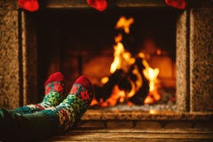 Πόδια στις μάλλινες κάλτσες από την εστία Η γυναίκα χαλαρώνει από θερμό στοκ φωτογραφίες με δικαίωμα ελεύθερης χρήσης Πόδια στις μάλλινες κάλτσες από την εστία Η γυναίκα χαλαρώνει από θερμό στοκ φωτογραφίες με δικαίωμα ελεύθερης χρήσης