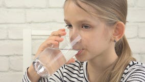 Πόσιμο νερό παιδιών, διψασμένο παιδί που μελετά το γυαλί του γλυκού νερού, κορίτσι στην κουζίνα στοκ εικόνες με δικαίωμα ελεύθερης χρήσης Πόσιμο νερό παιδιών, διψασμένο παιδί που μελετά το γυαλί του γλυκού νερού, κορίτσι στην κουζίνα στοκ εικόνες με δικαίωμα ελεύθερης χρήσης