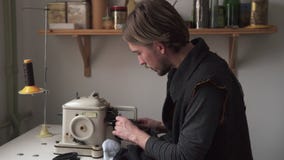 Ράβοντας γούνα ραφτών νεαρών άνδρων furrier στη μηχανή απόθεμα βίντεο Ράβοντας γούνα ραφτών νεαρών άνδρων furrier στη μηχανή απόθεμα βίντεο